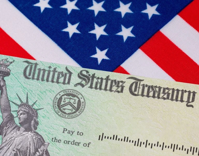 Treasury check and American Flag U.S. Treasury check laid over an American flag